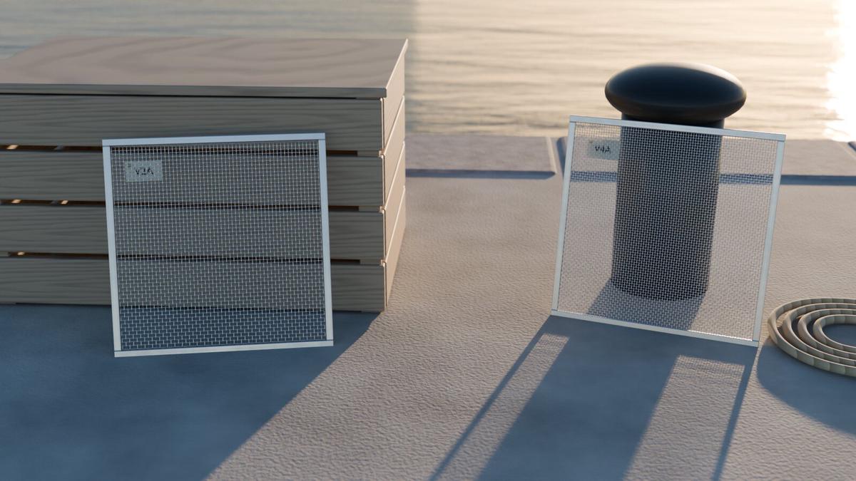 Two framed stainless steel wire mesh samples labelled V2A and V4A on a harbour quay at sunset