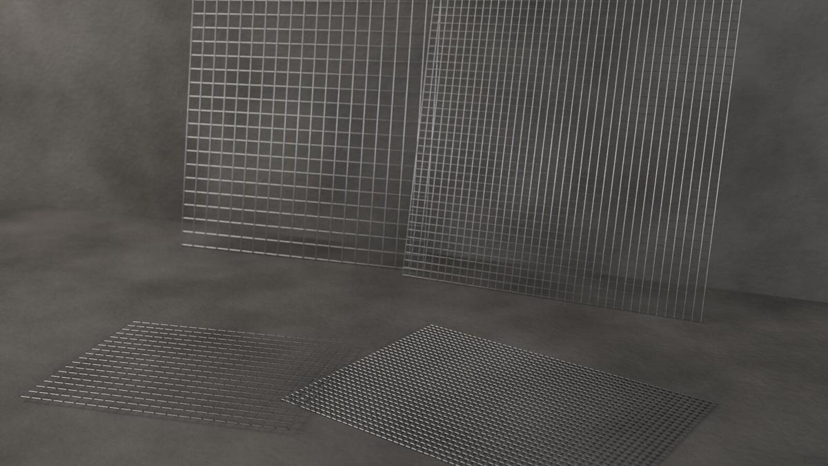 Welded stainless steel mesh panels leaning against a concrete wall, two more lying on the floor